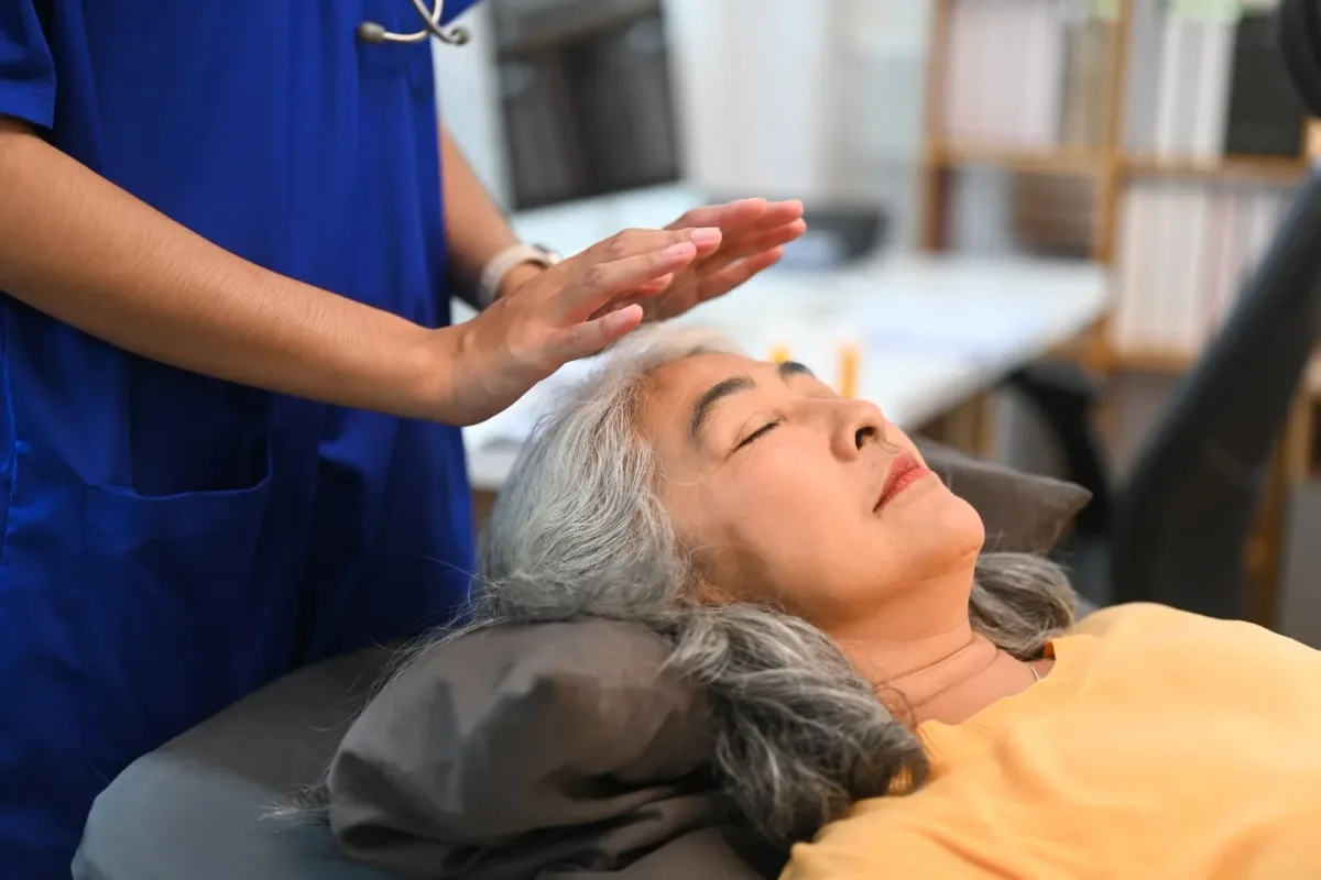 Maestra de Reiki proporcionando armonización energética a su cliente