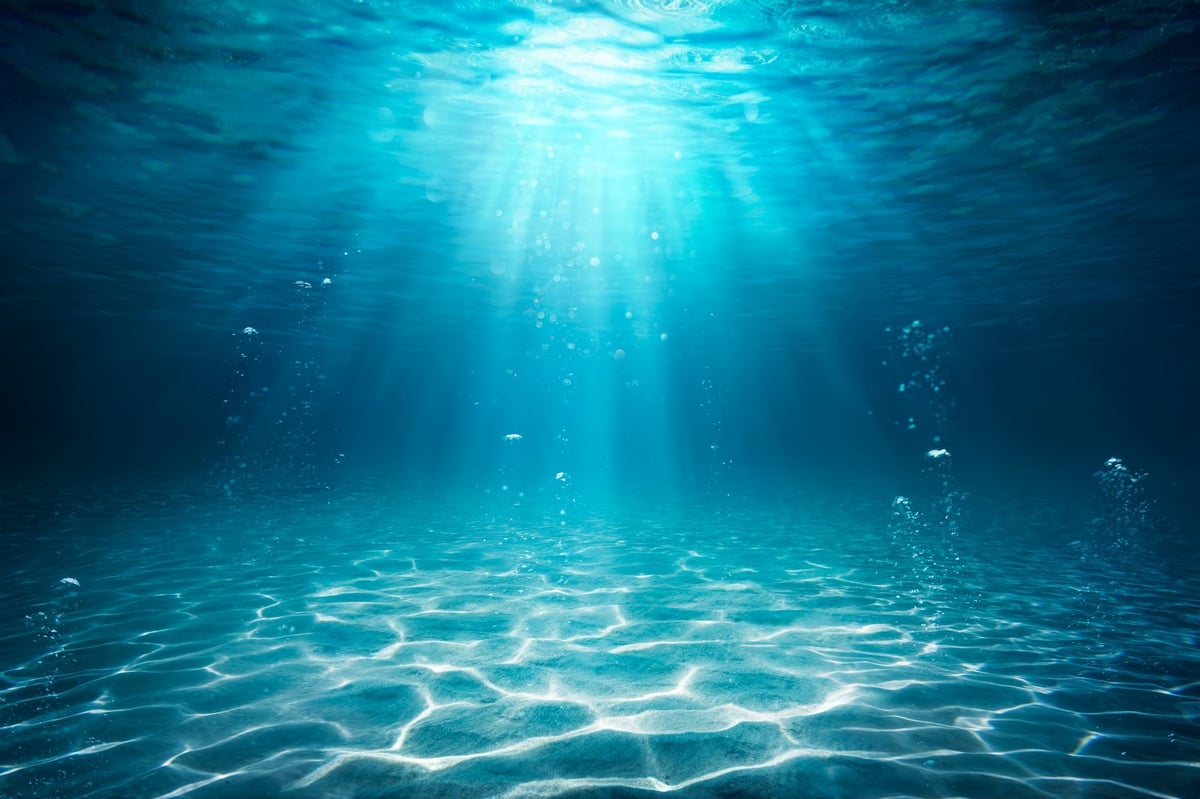 Océano con rayos de luz bajo el agua representando energía marina sanadora