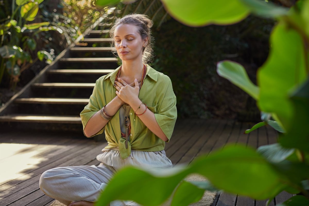 Mujer practicando meditación mindfulness en la naturaleza, respiración y calma interior