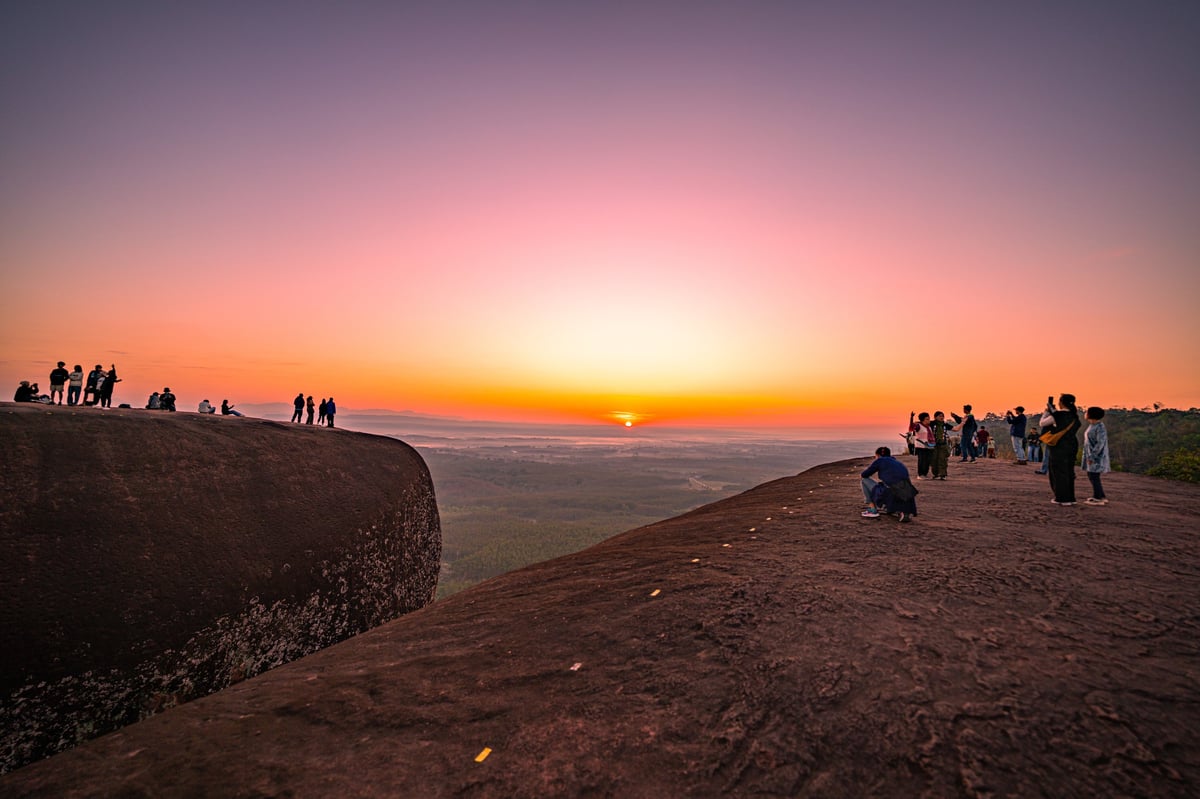 Persona contemplando el amanecer en un punto elevado, representando reflexión y nuevo comienzo